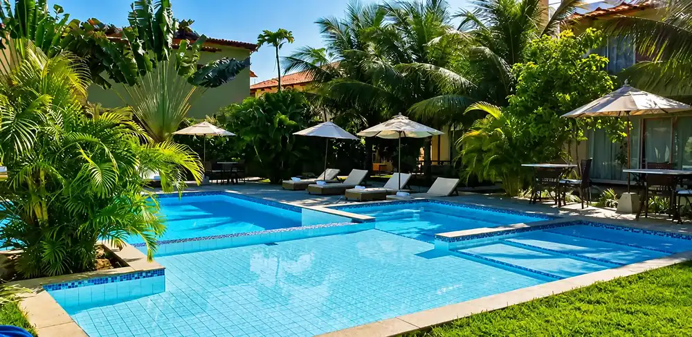 Duas piscinas ao ar livre no pátio ajardinado do Ravenala Hotel Boutique