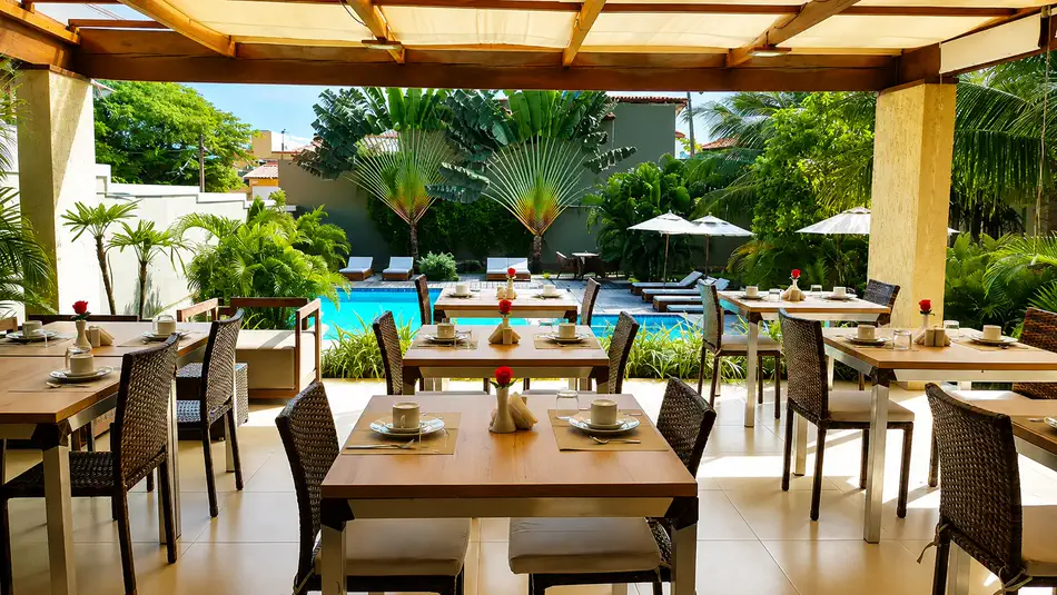 Terraço do café da manhã montado ao lado da piscina no Ravenala Hotel Boutique